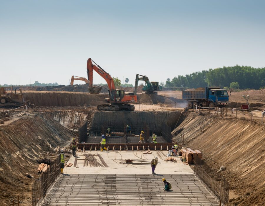 Close shot of heavy machines and construction workers working on a building